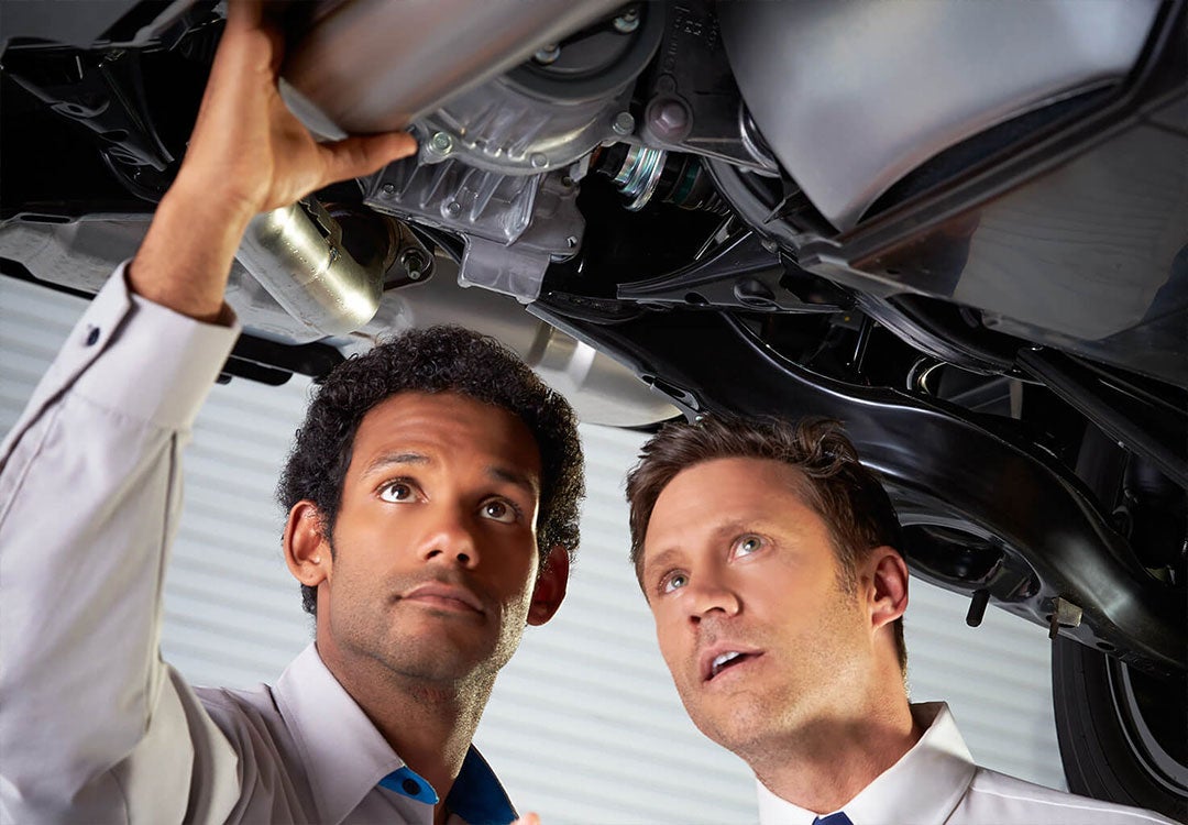 Two people inspecting a car